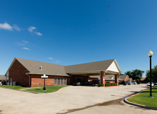 A well-maintained commercial building with a parking area under a clear blue sky.
