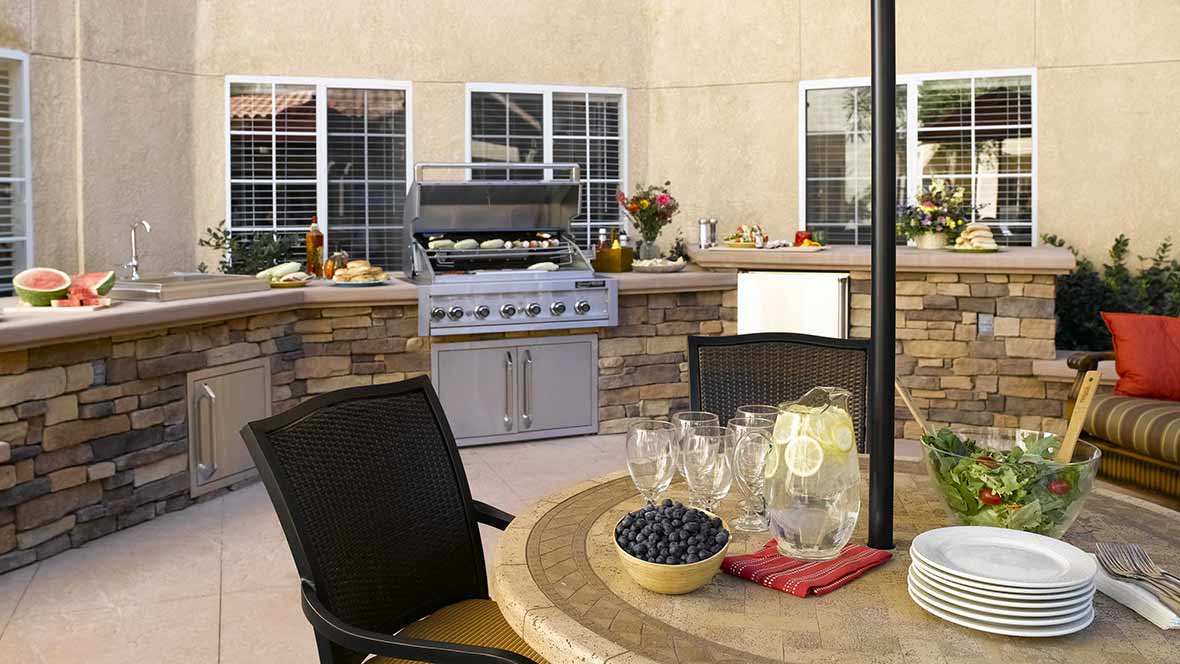 A cozy outdoor patio with a barbecue grill and seating area, perfect for gatherings.