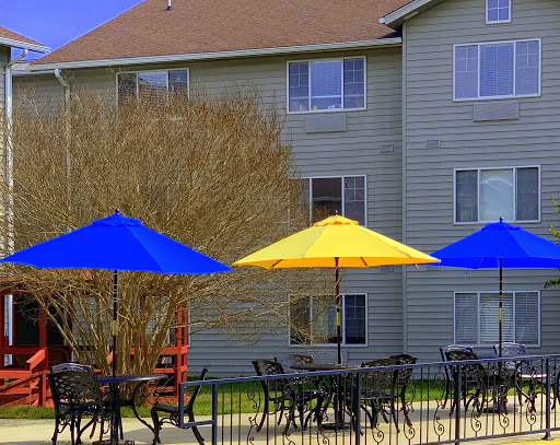 A vibrant outdoor seating area featuring colorful umbrellas against the backdrop of an apartment building.