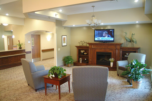 A cozy living room featuring comfortable seating, a television, and decorative plants.