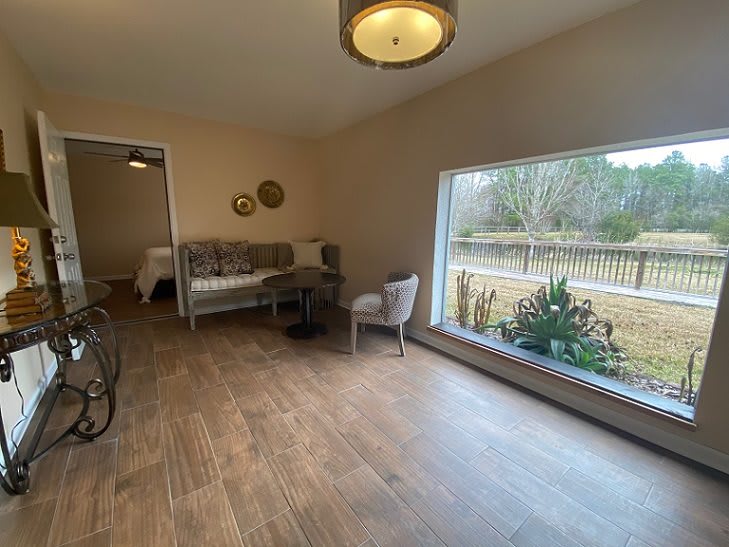 A modern living and dining area with wooden floors and a large window providing natural light.