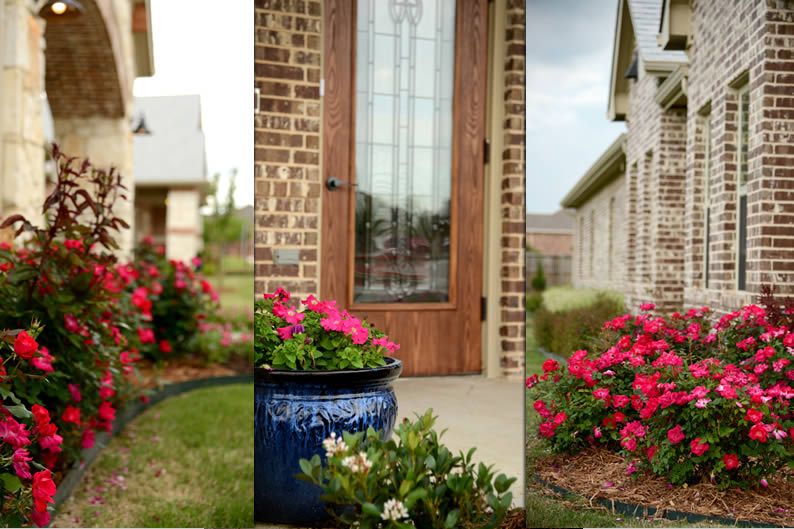 A beautifully landscaped brick house with vibrant pink flowers and potted plants near the front door.