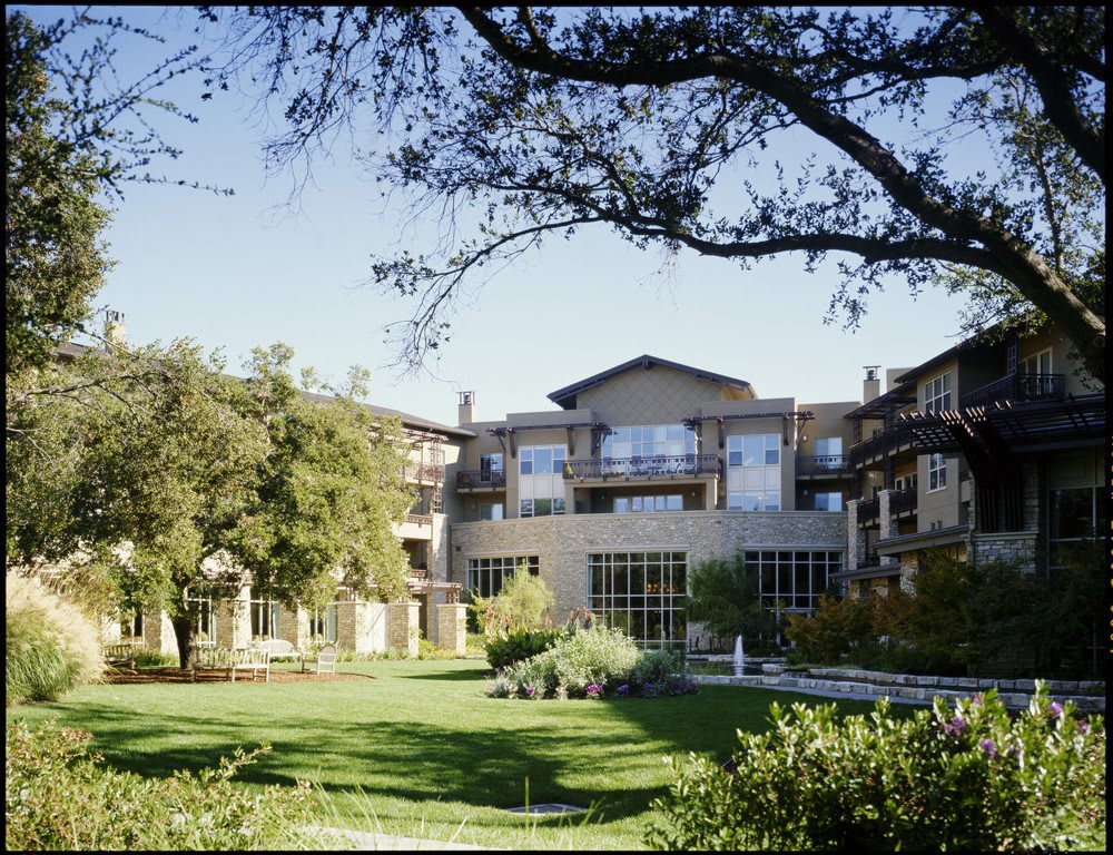 A building surrounded by trees and a well-kept lawn.