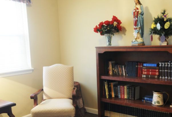 A cozy corner with a chair, bookshelf, and decorative elements.