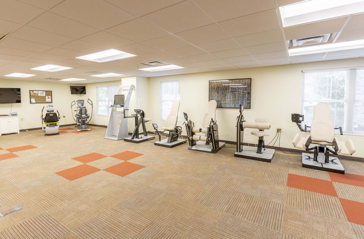 A spacious gym featuring various fitness equipment and ample lighting.