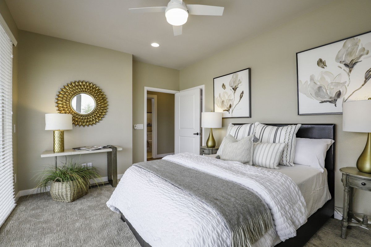 A modern bedroom with a neatly made bed, stylish decor, and contemporary artwork.