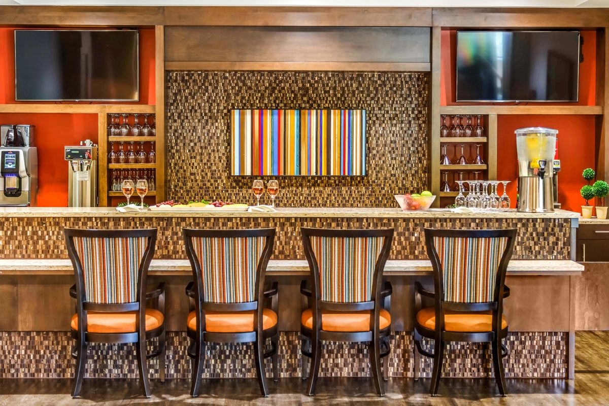 A stylish bar interior featuring colorful striped chairs and decor.