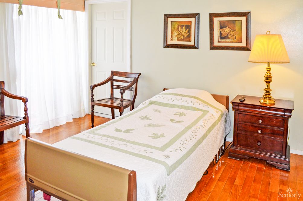 A cozy bedroom with a single bed, wooden flooring, and elegant decor.