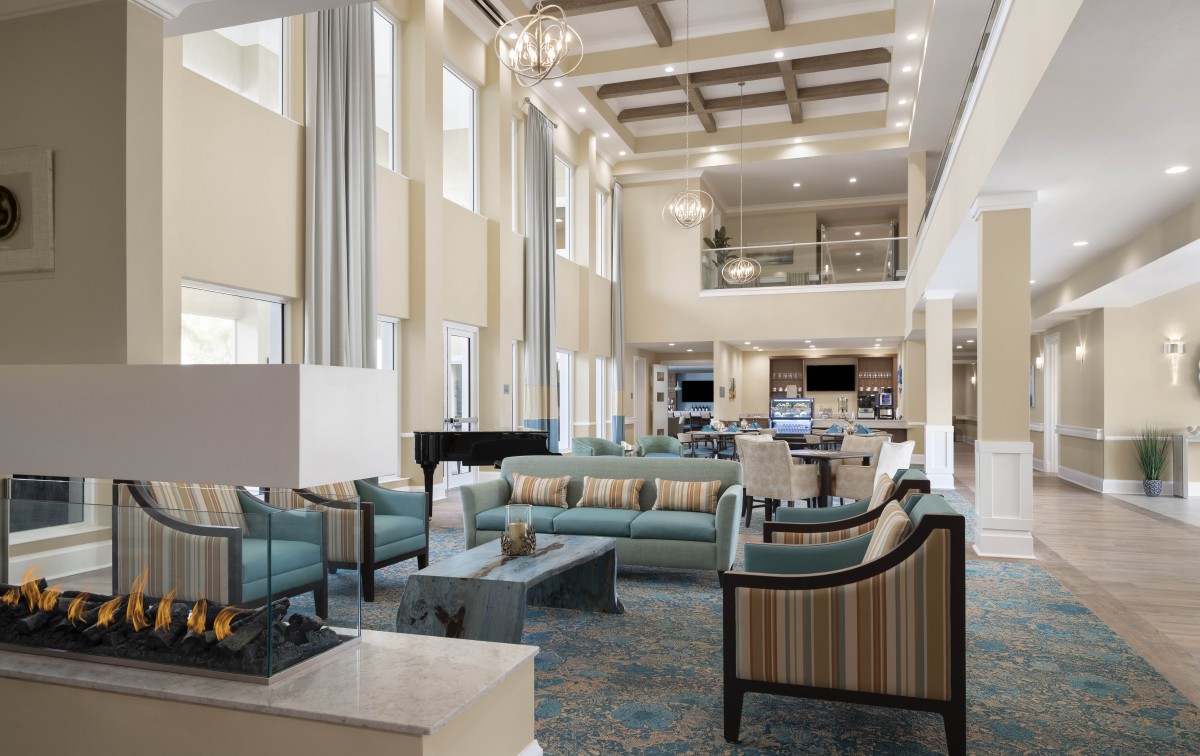 A luxurious living room with high ceilings, elegant furnishings, and a modern design aesthetic.