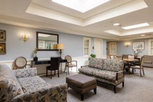 A cozy living room with sofas, chairs, and a skylight providing natural light.