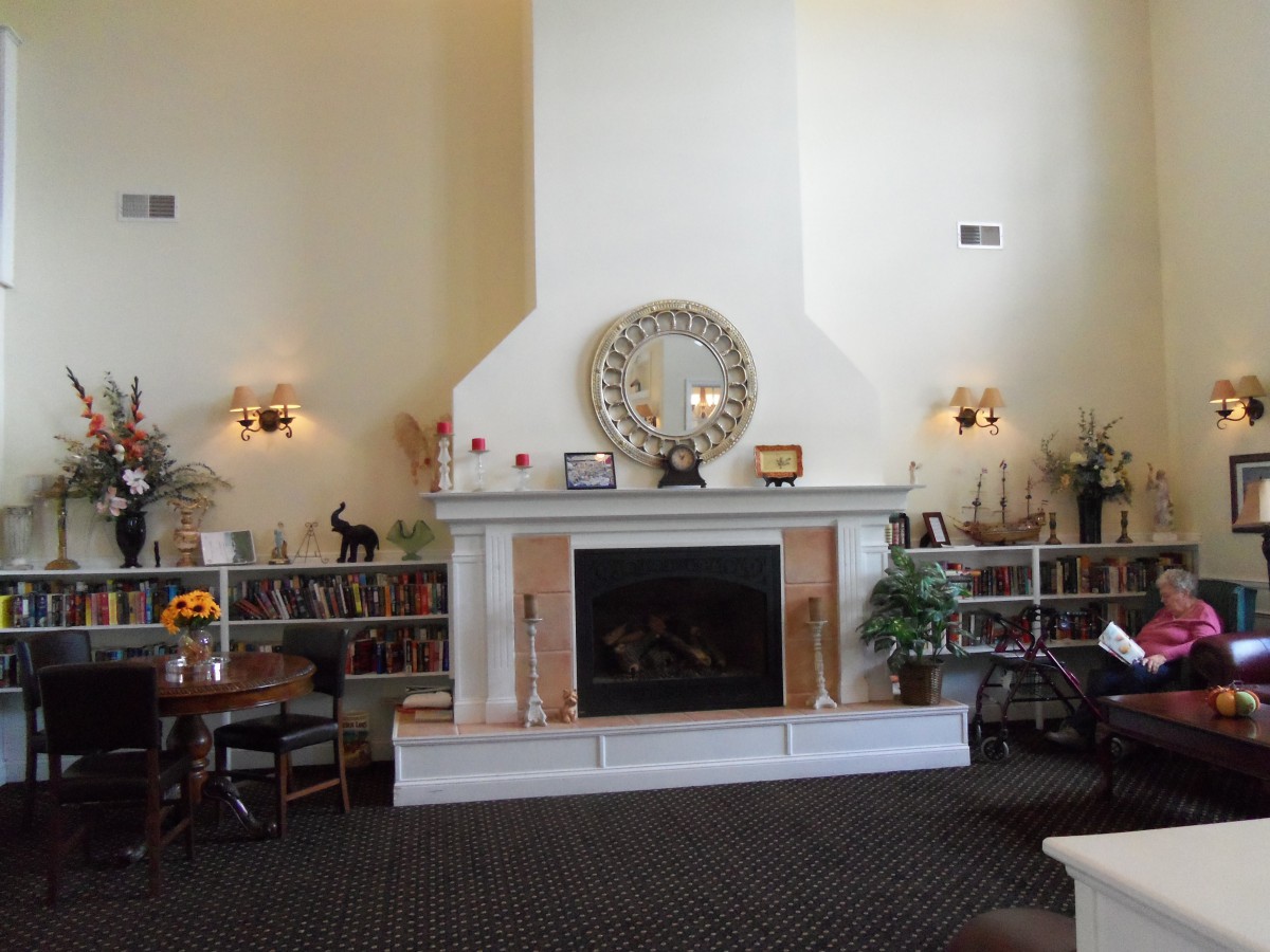A cozy living room featuring a fireplace with decorative shelves on either side and a large mirror above.