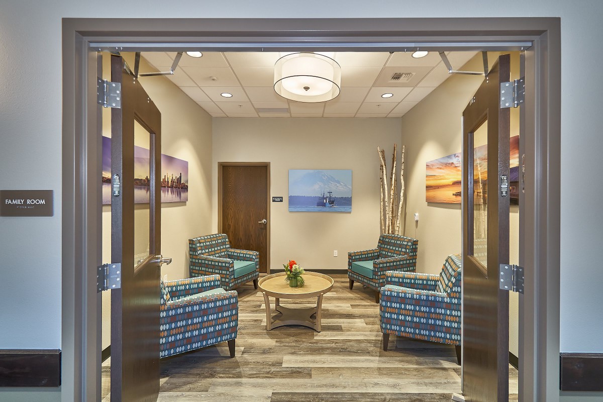 A cozy waiting room with patterned chairs and soothing artwork on the walls.