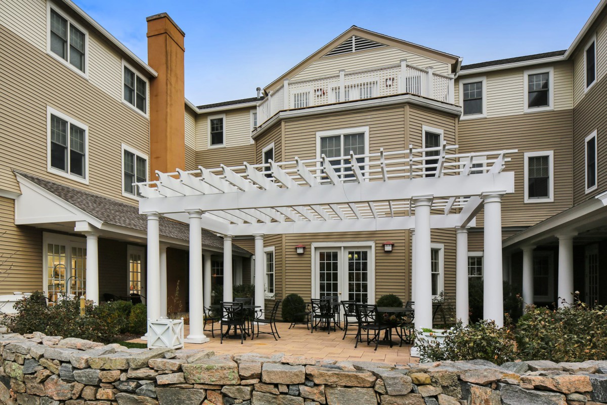 A residential building with a spacious outdoor patio and pergola.