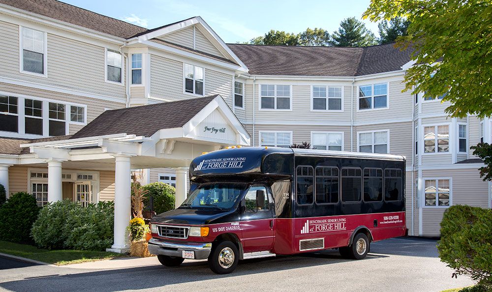 A shuttle bus parked in front of a hotel.