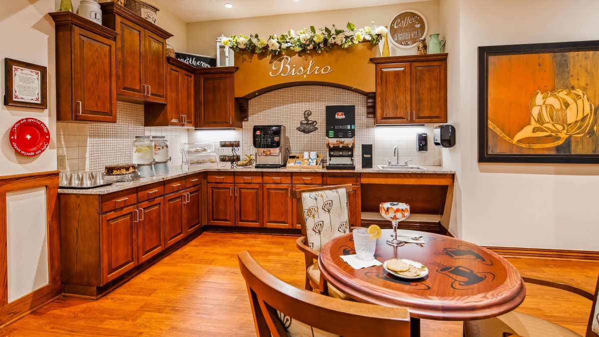 A cozy kitchen bistro with warm wooden cabinets and a small seating area.