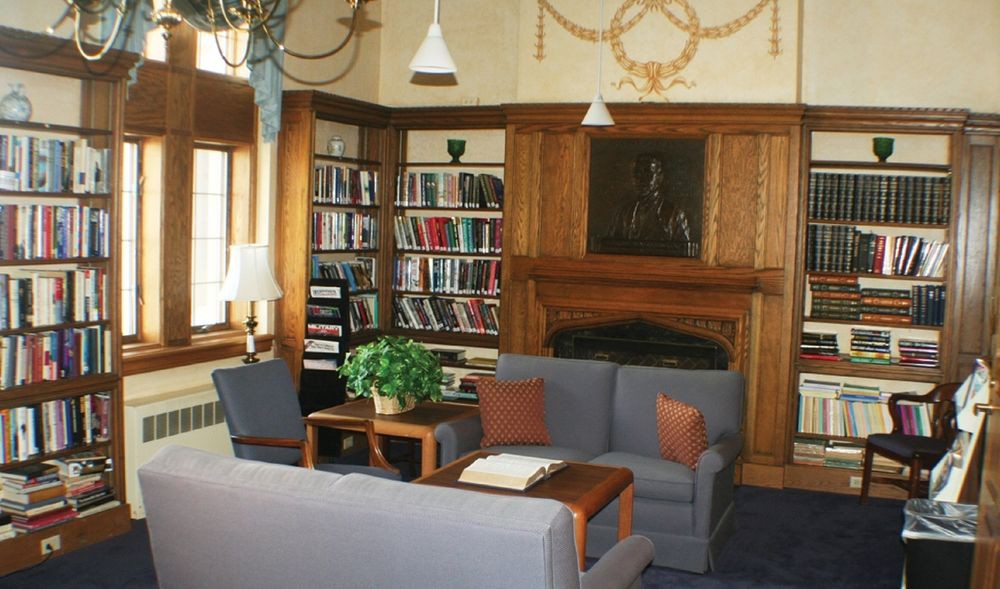 A cozy library reading area with bookshelves and comfortable seating.