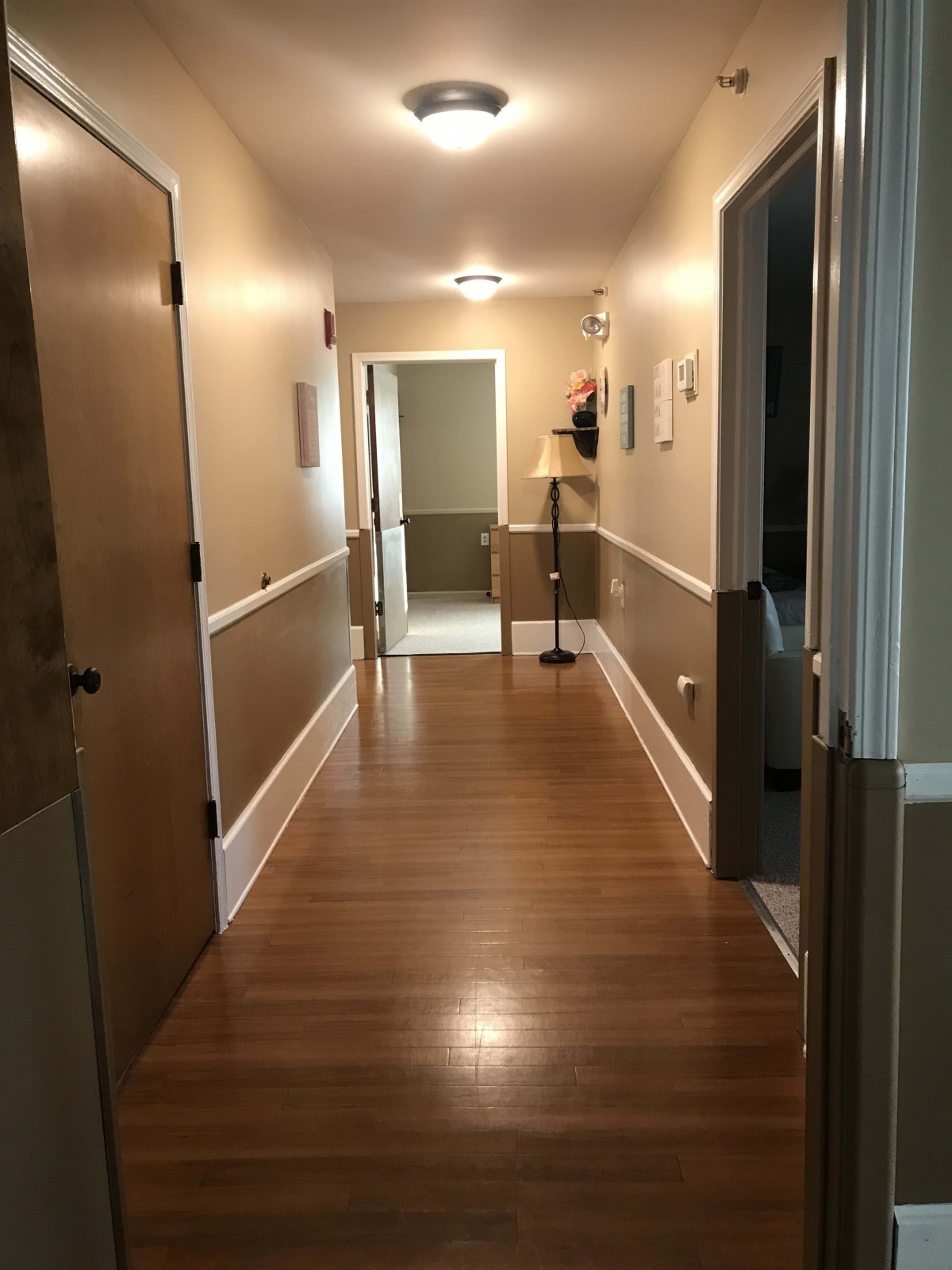 A well-lit hallway with wooden floors and warm lighting.