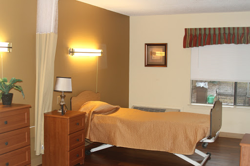 A serene bedroom setting featuring a single bed, bedside lamp, and warm lighting.