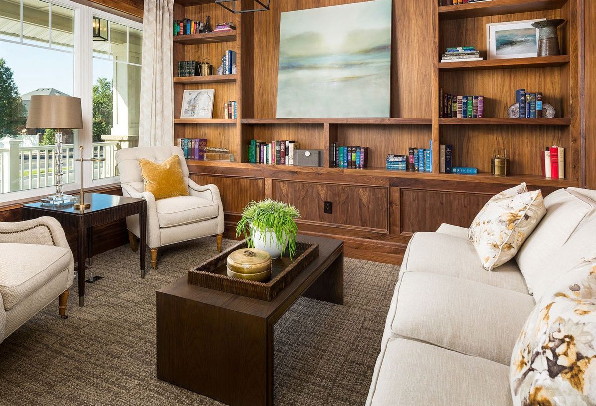 A cozy living room with a modern design featuring wooden bookshelves, a comfortable sofa, and stylish decor.