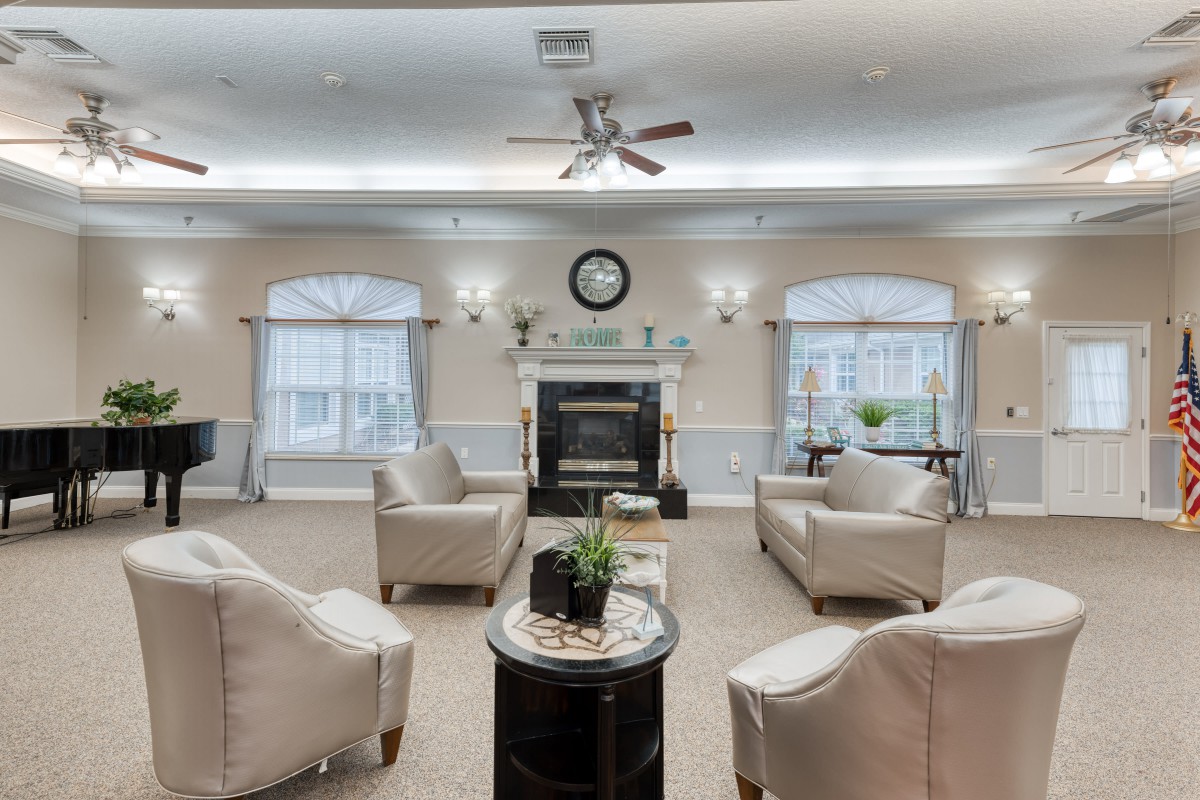 A cozy living room with elegant armchairs arranged around a fireplace.