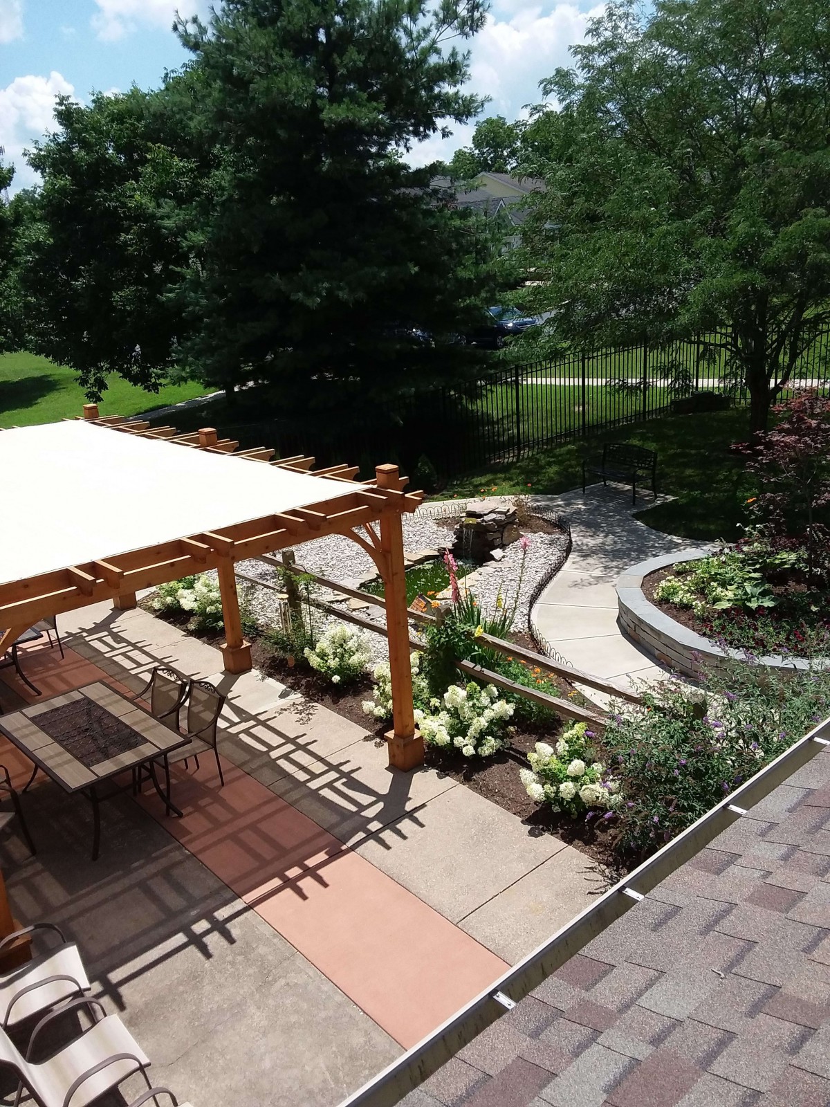 A beautifully landscaped backyard with a patio featuring a pergola and outdoor seating area.