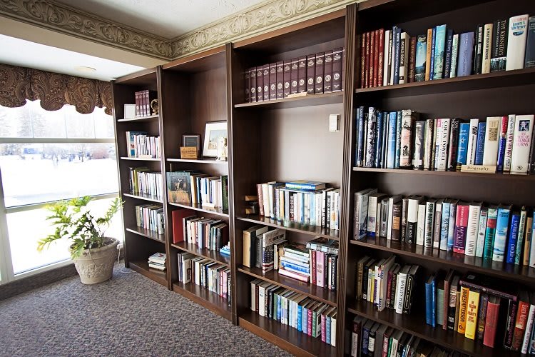 A cozy library corner with wooden bookshelves filled with a variety of books.