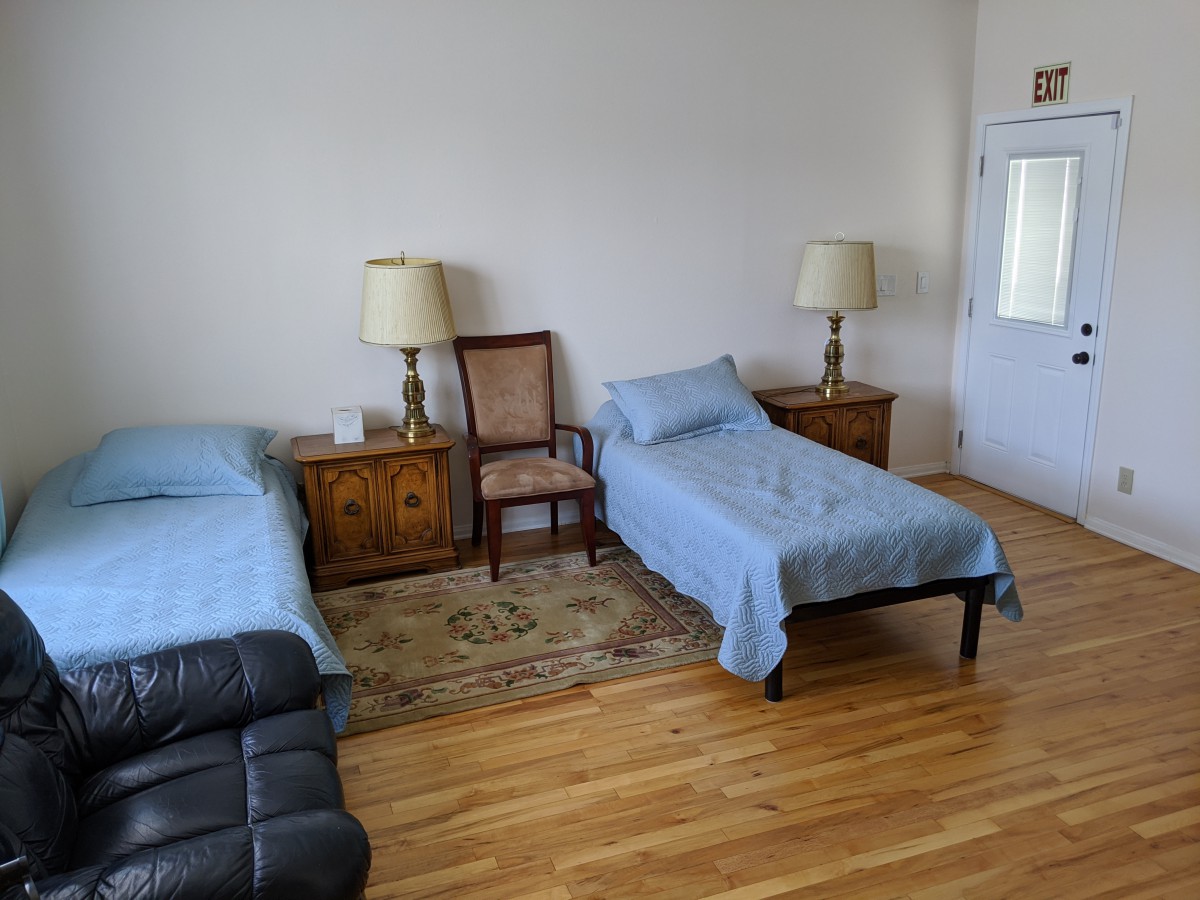 A cozy bedroom with two single beds, a pair of bedside lamps, and wooden furniture.