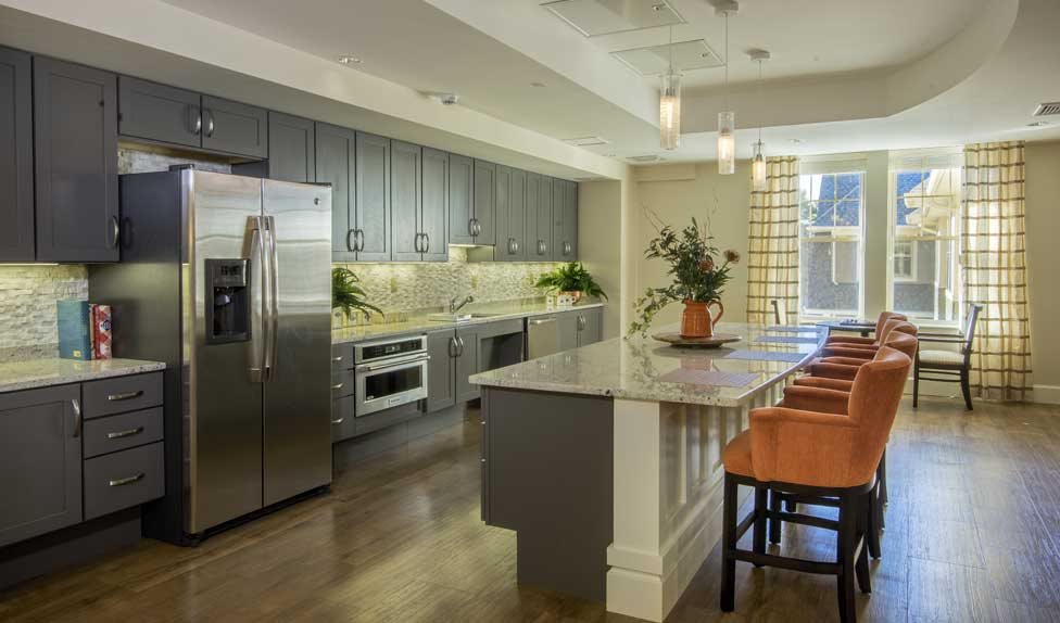 A modern kitchen featuring stainless steel appliances and a spacious island with pendant lighting.
