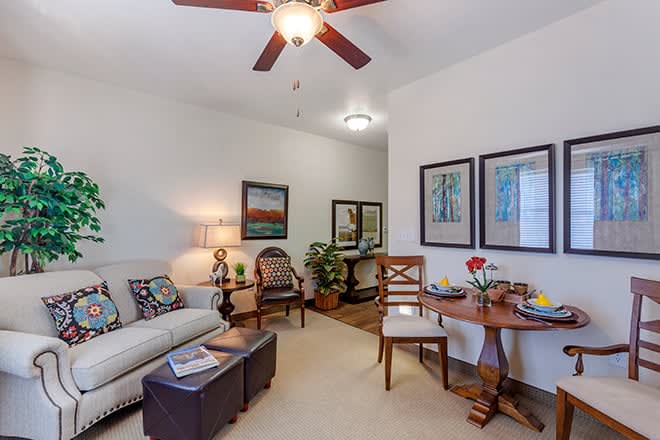 A cozy living room with a sofa, armchairs, and decorative wall art.