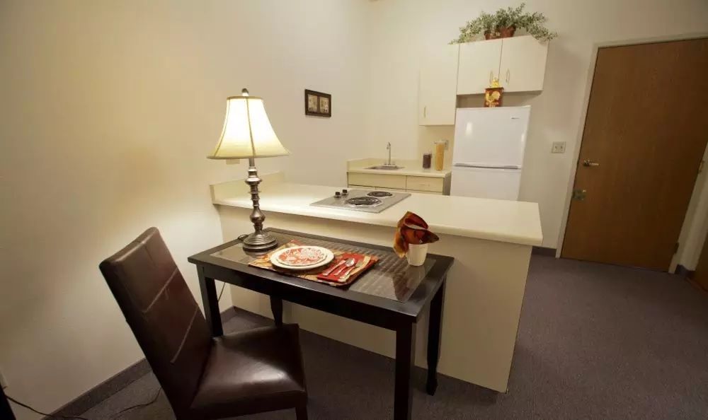 Cozy kitchen and dining area with a small table and lamp.