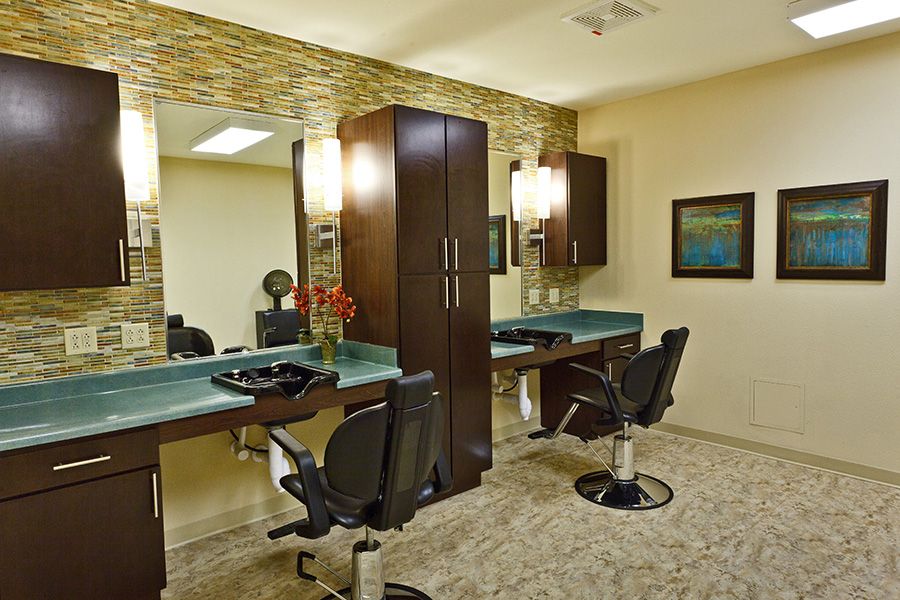 A modern hair salon with stylish interior, featuring mirrors and comfortable seating.
