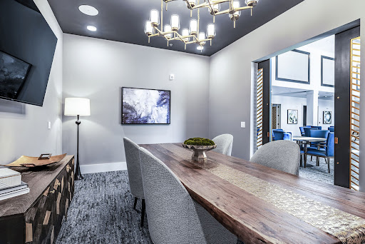 A stylish dining room featuring modern decor, a wooden table, and an elegant chandelier.