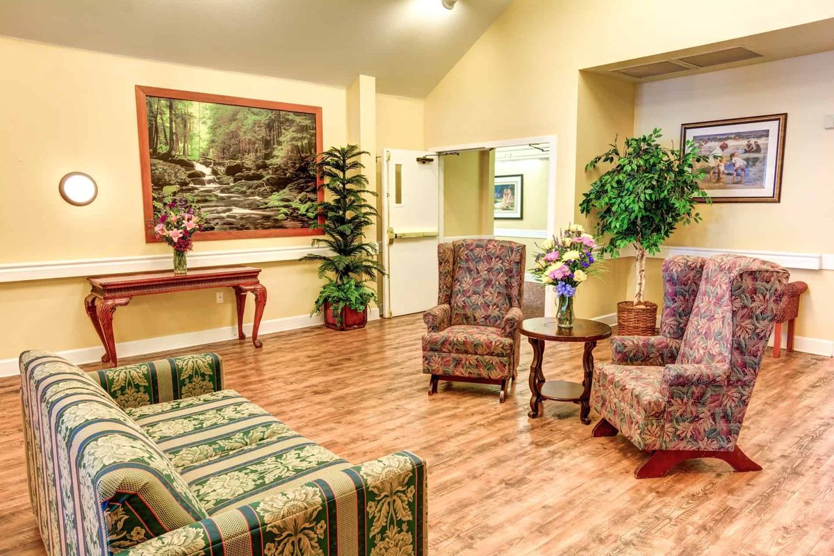 A cozy lobby with comfortable seating, decorative plants, and wall art.