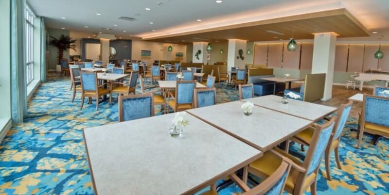 A modern dining area with neatly arranged tables and chairs.