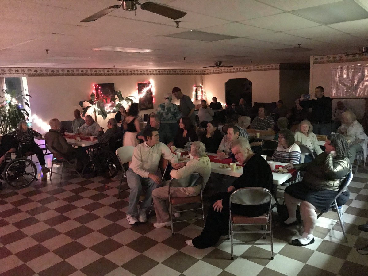 A group of people gathered in a dimly lit room for an event.