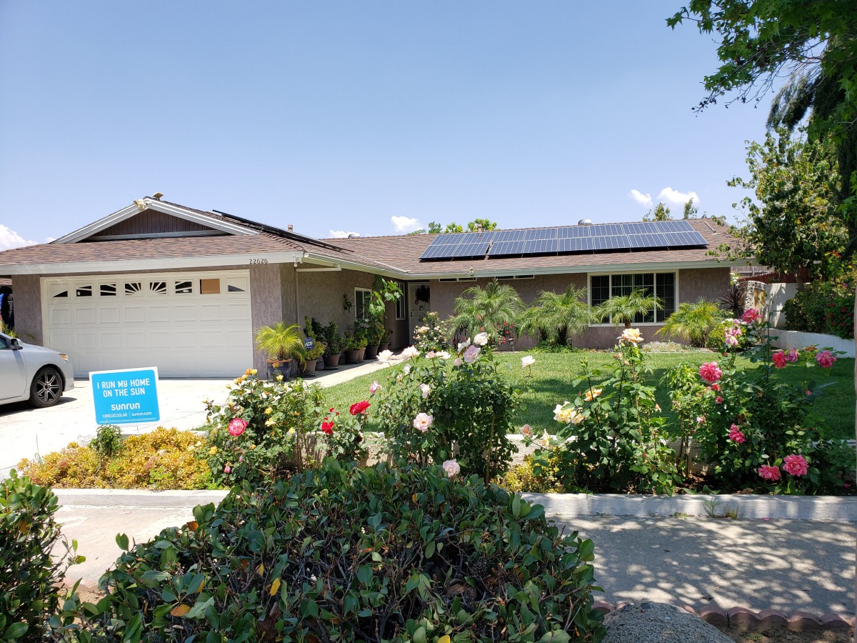 A suburban house with solar panels and a well-maintained garden.