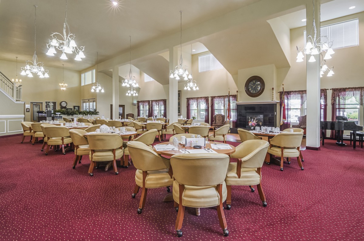 Elegant dining room with plush seating and chandeliers.
