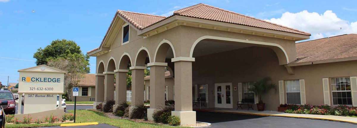 A building with a series of arches at the entrance, featuring a tiled roof.