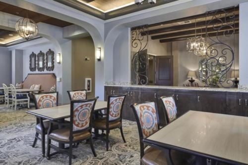 Elegant dining area with ornate chairs, tables, and a chandelier.