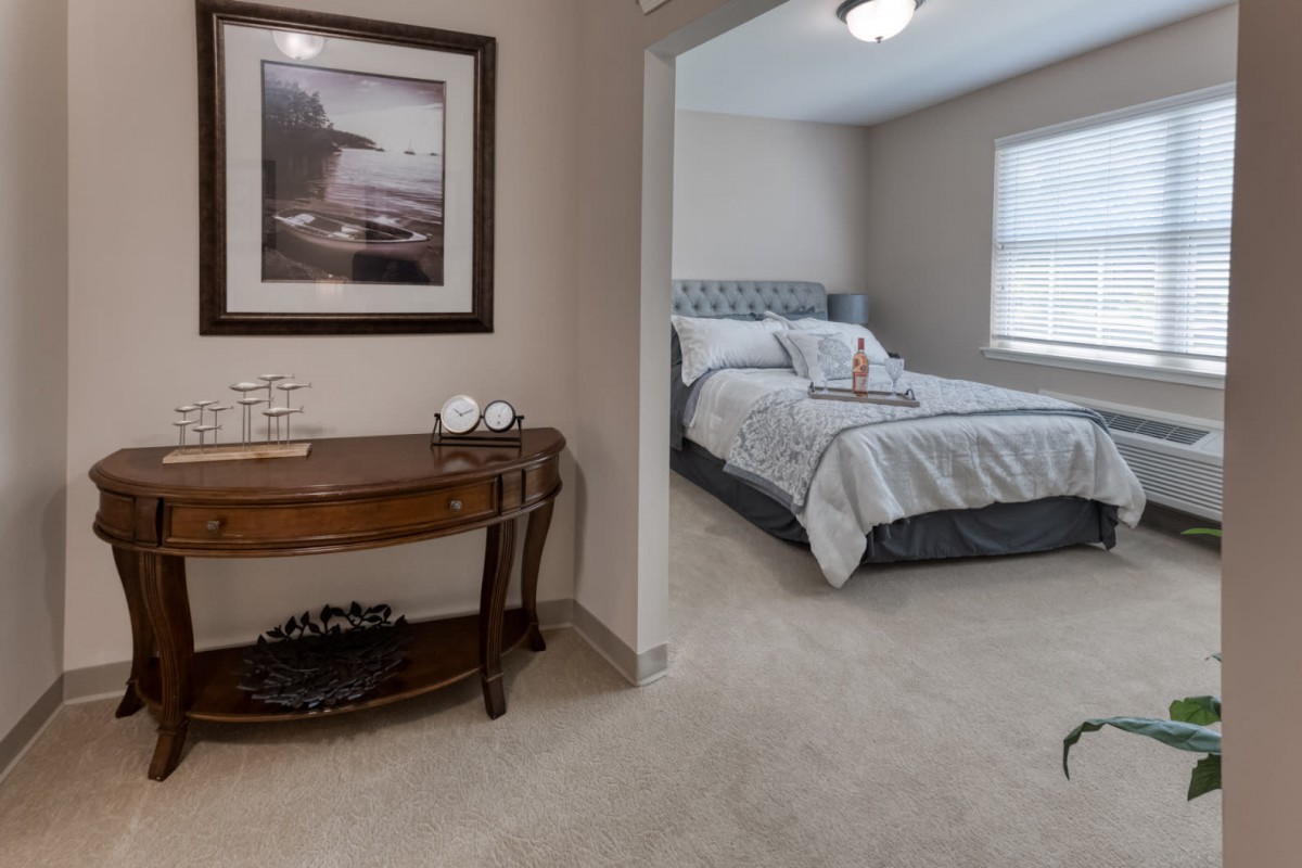 A cozy bedroom with a neatly made bed and decorative elements.