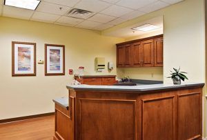 A reception area with a wooden counter and cabinets in an office setting.