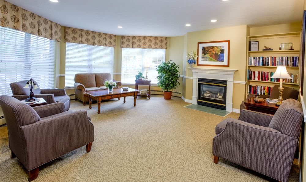 A cozy living room with comfortable seating, a fireplace, and large windows.