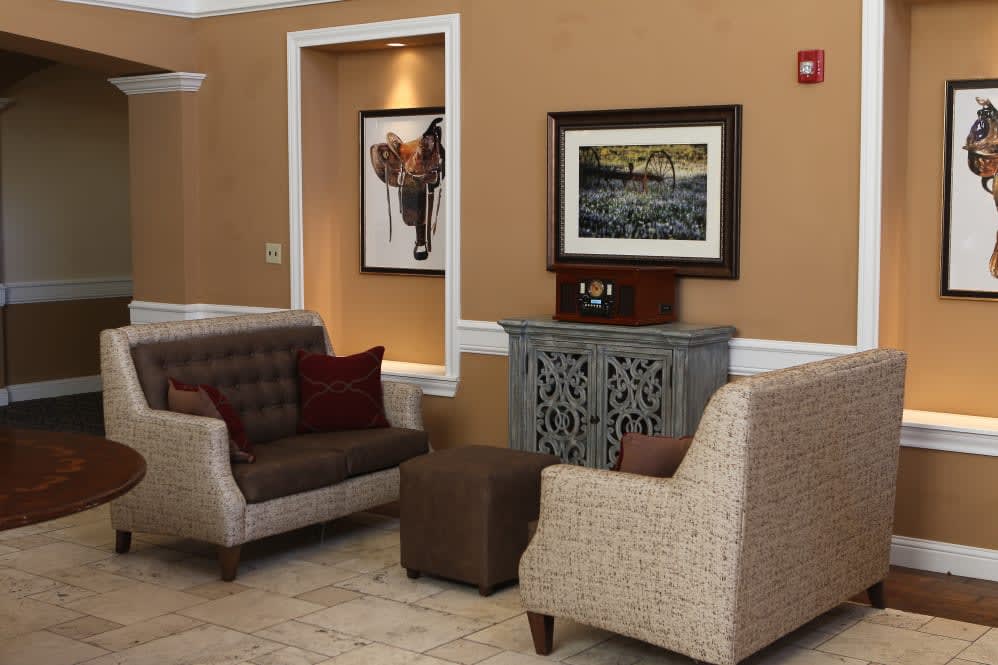 A cozy seating area featuring comfortable chairs and elegant artwork on the walls.