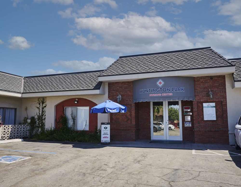 A restaurant building with a blue umbrella outside on a sunny day.