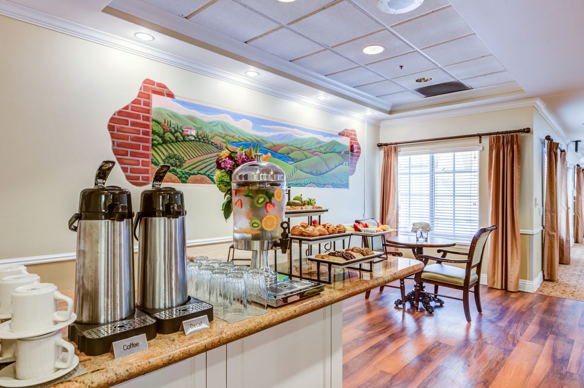 A cozy breakfast area featuring a coffee station and buffet with seating arrangements.