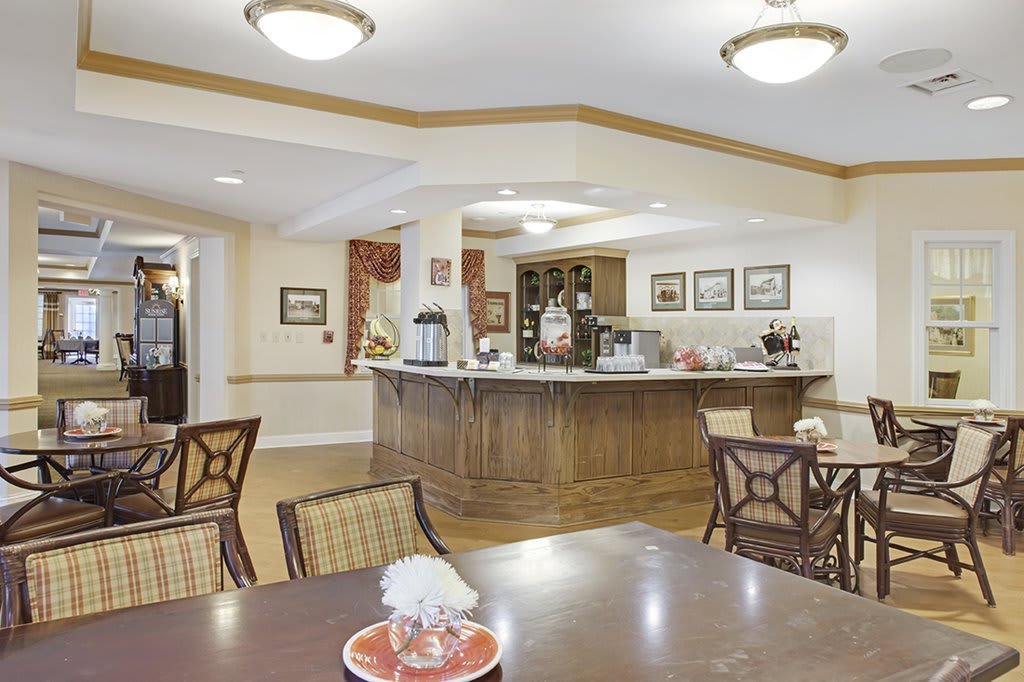 A cozy dining area with wooden furniture, decorative items, and a central counter.