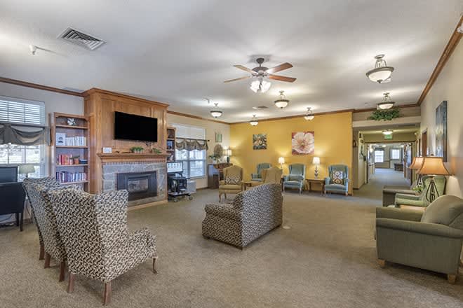 A cozy living room with ample seating, featuring a fireplace and television.
