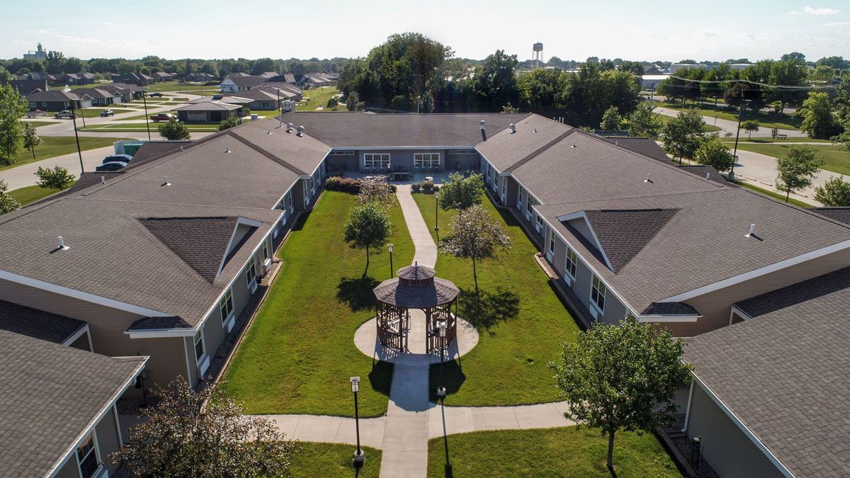 Aerial view of a building complex with a central courtyard featuring a gazebo and surrounding greenery.