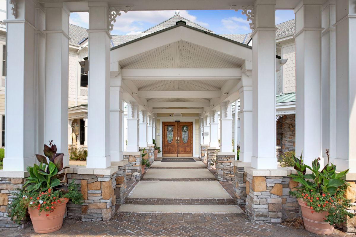 A symmetrical entrance featuring columns and a portico leading to the main doors of a building.