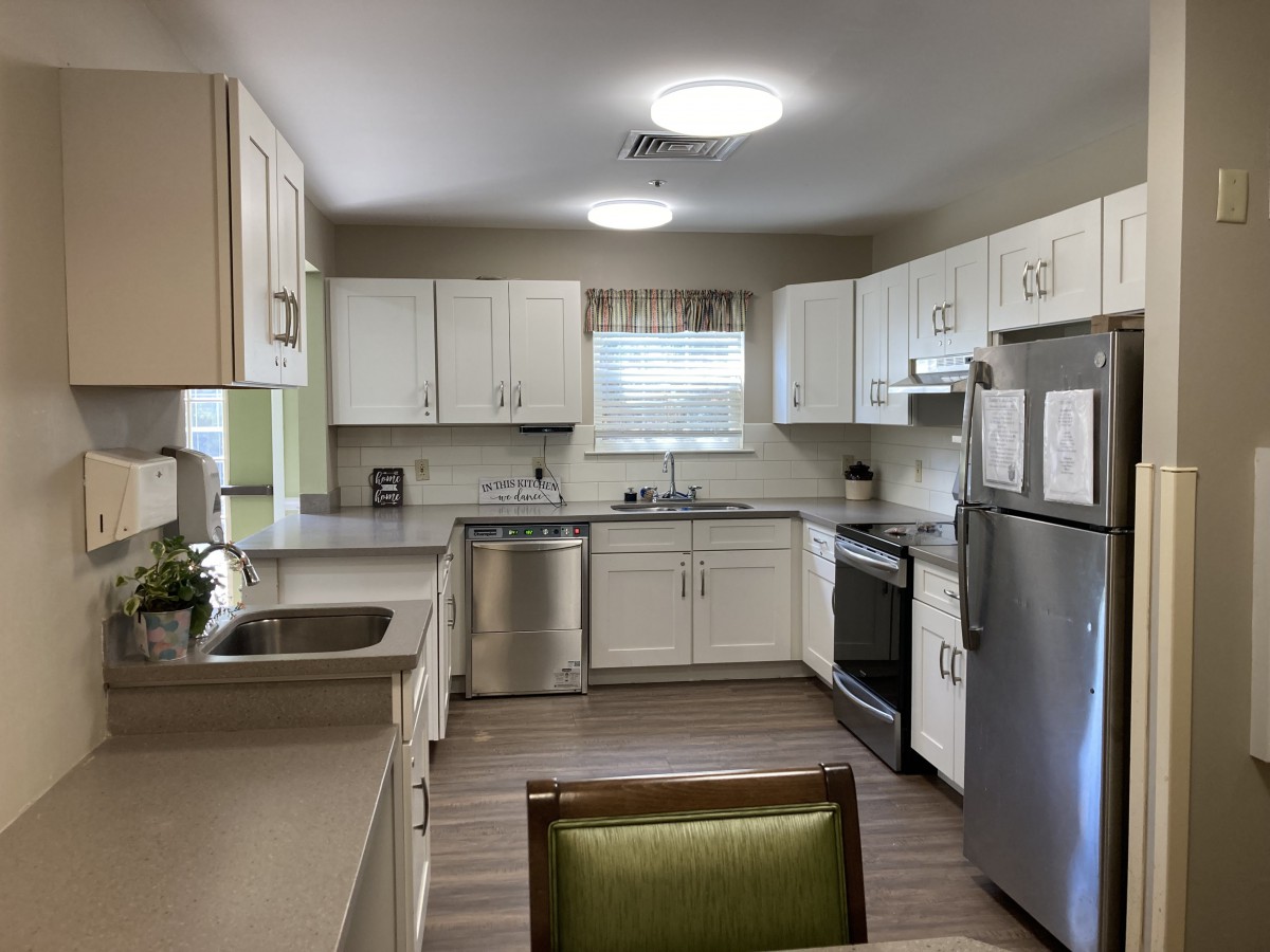 A modern kitchen with white cabinets and stainless steel appliances.